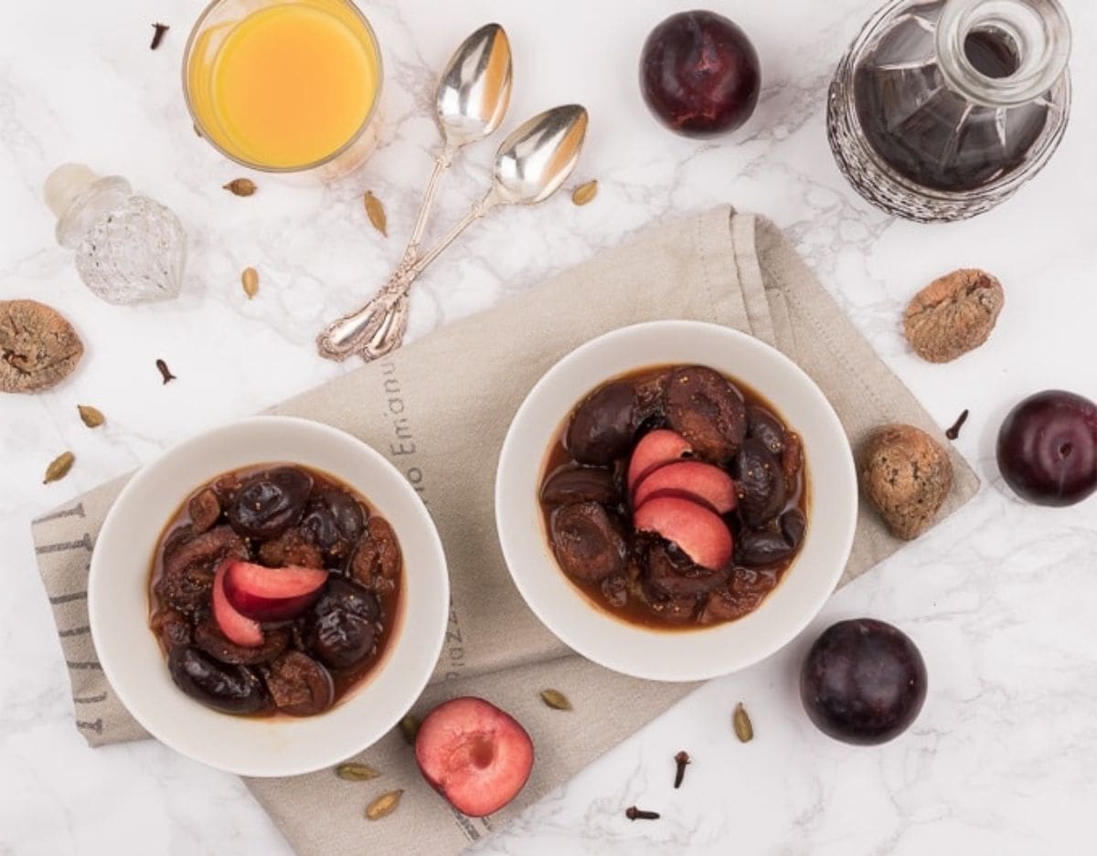 Juicy Prune Compote with Dried Figs, Cinnamon, Cloves and Cardamom two bowls of plum compote on a kitchen towel