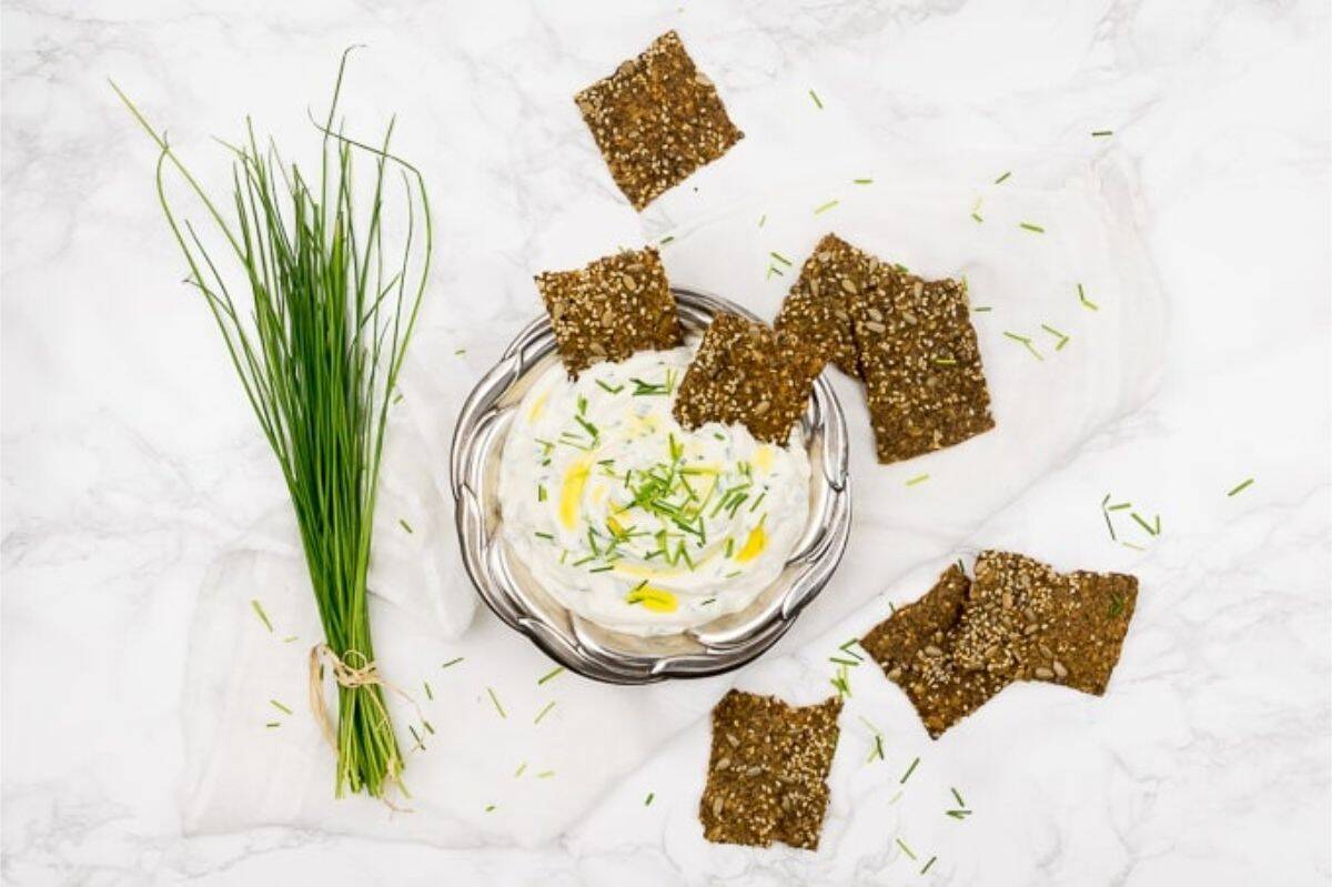 Cream Cheese Dip with Chives and Flaxseed Oil Vegan chives cream cheese dip next to a small bunch of chives and multi-seed crackers