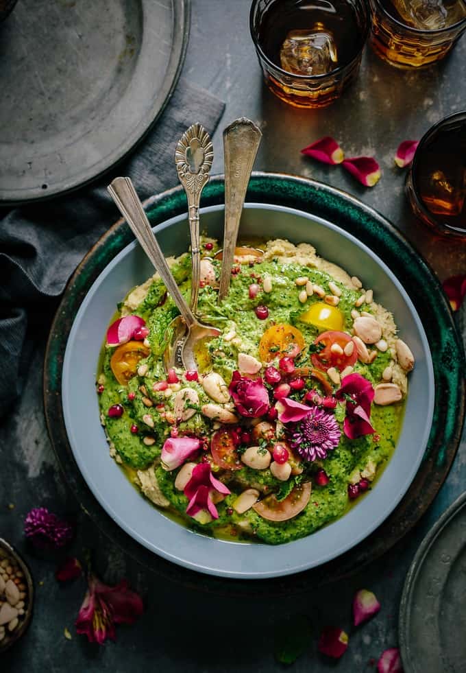 Plate with colorful food, tomatoes, and blossoms, representing the beautiful vegan dishes made by celebrity chefs